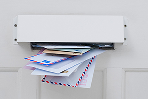 Mail slot in door filled with mail